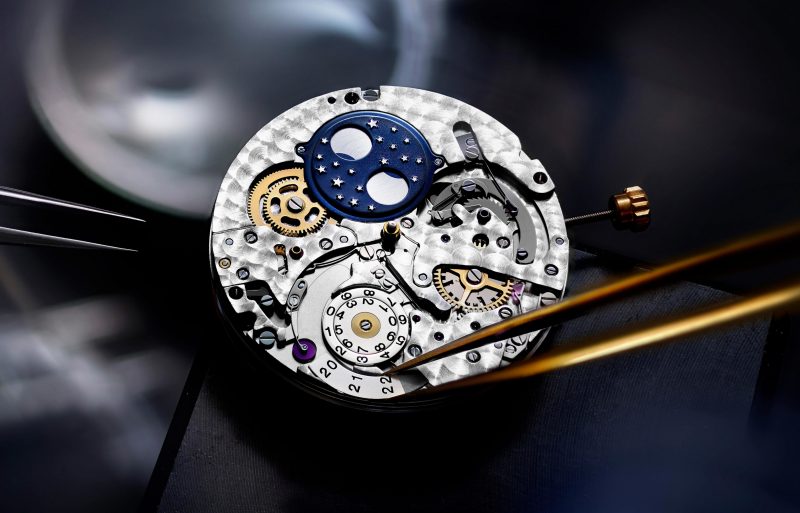 该深色背景特写图展示了IWC 万国表腕表机械装置,Close-up image showing IWC watch mechanism on dark background