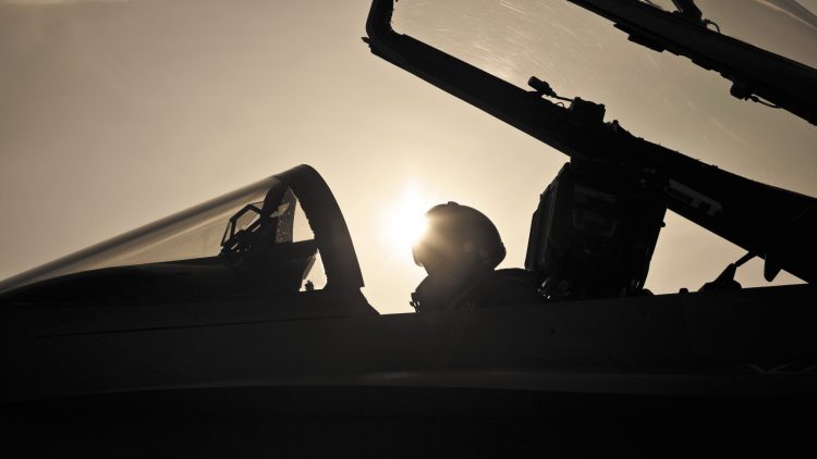 The silhouette of a cockpit of a modern fighterjet.