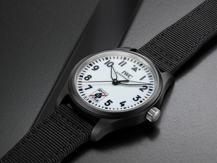 Pilot’s Watch Automatic 41 Black Aces laying on a dark surface, black dial, black fabric strap and white dial with black lettering