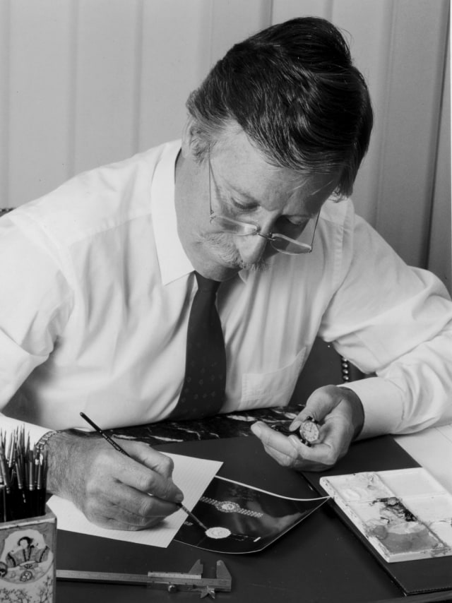 Black and white photo of the legendary IWC watch designer Gérald Genta in white shirt designing in his desk.