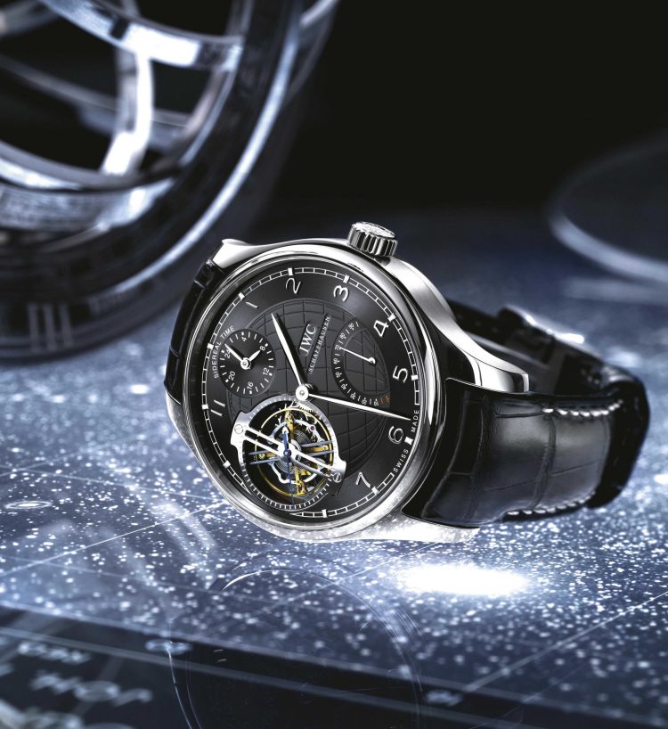 IWC葡萄牙系列恒星陀飞轮腕表,黑色表盘、铂金表壳与黑色鳄鱼皮表带,置于蓝色背景之上