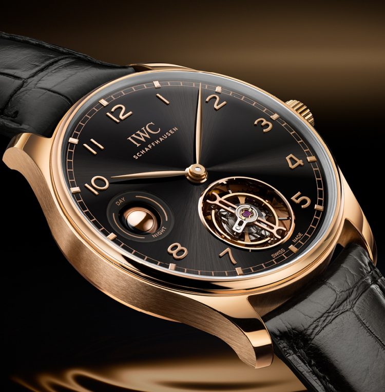 IWC葡萄牙系列手动上链陀飞轮昼夜显示腕表,搭载黑色表盘、18K Armor Gold®硬金表壳和Santoni黑色鳄鱼皮表带。