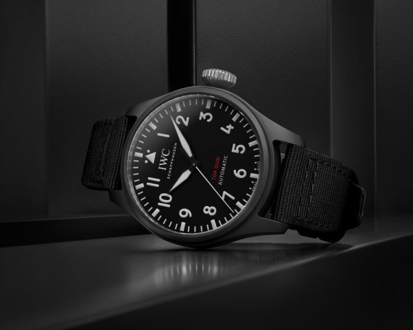 Front image of a black dial watch with a black textile strap