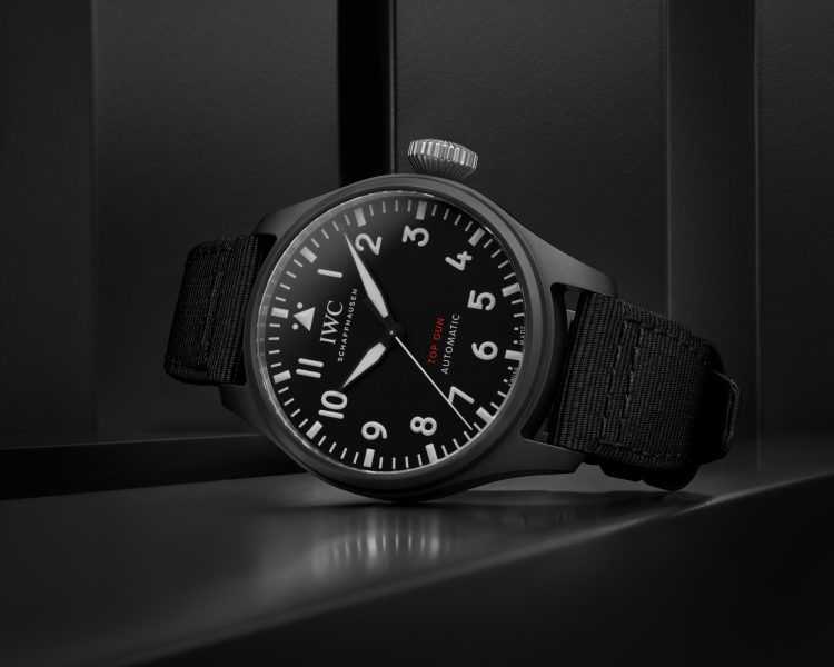 Front image of a black dial watch with a black textile strap